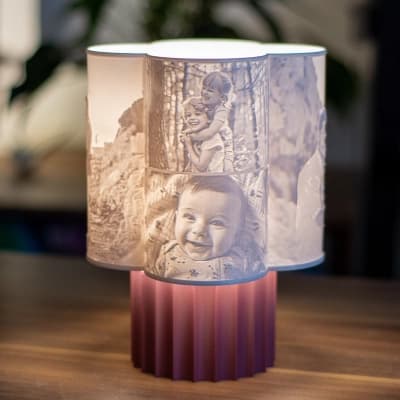 Flora personalizirana 3D foto lampa s više obiteljskih portreta koji sjaje na ružičastom postolju u modernom interijeru.