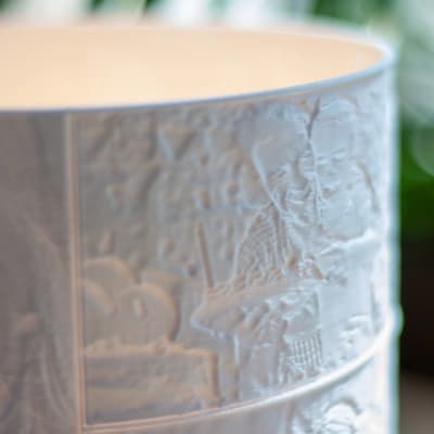 Krupni plan detalja personaliziranog 3D printanog sjenila lampe s ugraviranim slikama.